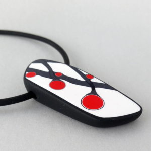 Handmade necklace with a single bead showing a graphic flower bud motif in red, on a white background with a charcoal border. It is approximately 2.6 cm wide and 6.4 cm long and hangs on a black adjustable cord.