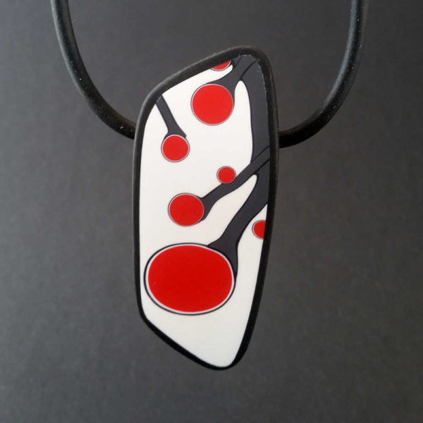 Handmade necklace with a single bead showing a graphic flower bud motif in red, on a white background with a charcoal border. It is approximately 2.6 cm wide and 6.4 cm long and hangs on a black adjustable cord.