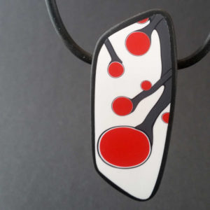 Handmade necklace with a single bead showing a graphic flower bud motif in red, on a white background with a charcoal border. It is approximately 2.6 cm wide and 6.4 cm long and hangs on a black adjustable cord.