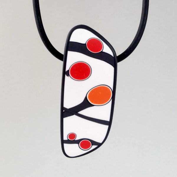 Handmade pendant showing a graphic flower bud motif in orange tones, on a white background with a charcoal border. It is approximately 2.6 cm wide and 6.4 cm long and hangs on a black adjustable cord.