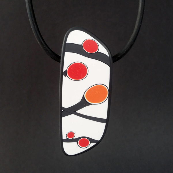 Handmade pendant showing a graphic flower bud motif in orange tones, on a white background with a charcoal border. It is approximately 2.6 cm wide and 6.4 cm long and hangs on a black adjustable cord.