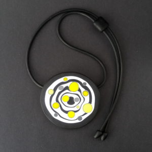 Large handmade pendant with organically-shaped concentric black and white circles, and irregular dots of bright yellow. It is approximately 6.6cm in diameter and hangs on a black adjustable cord.