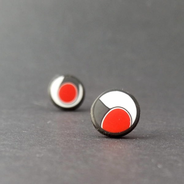 Handmade stud earrings with asymmetrical abstract flower bud pattern in red, on a white background with a charcoal border. Surgical stainless steel posts.