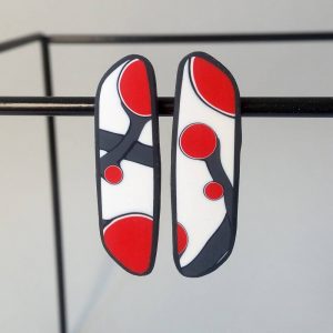 Handmade post earrings with asymmetrical flower bud pattern in red, on a white background with a charcoal border. Surgical stainless steel posts.
