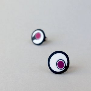 Handmade stud earrings with asymmetrical abstract flower bud pattern in plum tones, on a white background with a charcoal border. Surgical stainless steel posts.