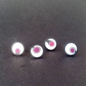 Handmade stud earrings with asymmetrical abstract flower bud pattern in plum tones, on a white background with a charcoal border. Surgical stainless steel posts.