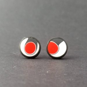 Handmade stud earrings with asymmetrical abstract flower bud pattern in red, on a white background with a charcoal border. Surgical stainless steel posts.