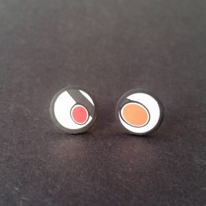 Handmade stud earrings with asymmetrical abstract flower bud pattern in orange tones, on a white background with a charcoal border. Surgical stainless steel posts.