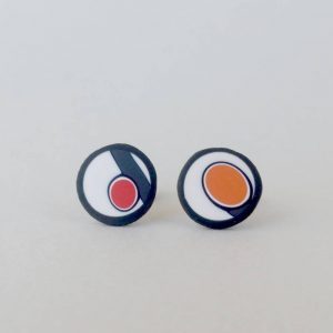 Handmade stud earrings with asymmetrical abstract flower bud pattern in orange tones, on a white background with a charcoal border. Surgical stainless steel posts.