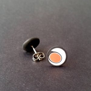Handmade stud earrings with asymmetrical abstract flower bud pattern in orange tones, on a white background with a charcoal border. Surgical stainless steel posts.
