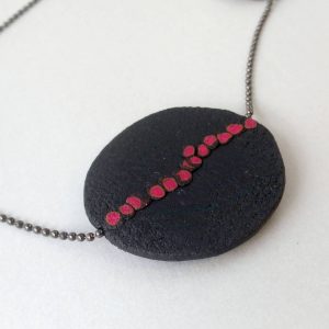 Handmade long necklace with individually crafted flat beads in vibrant orange and magenta on a black, textured background. Length approx. 120cm.