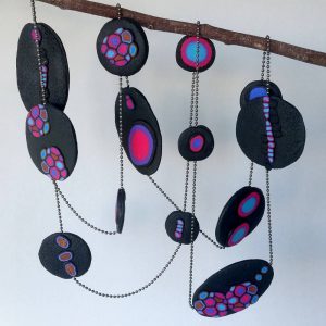 Handmade long necklace (120cm) with individually crafted organically shaped beads in a vivid combination of purple and magenta dots.