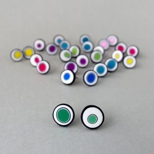 Handmade stud earrings with organic circles of emerald green on a white background with a black border.