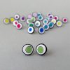 Handmade stud earrings with organic circles of lime green on a white background with a black border.