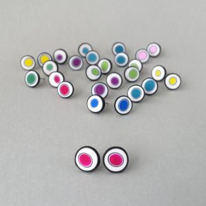 Handmade stud earrings with organic circles of magenta on a white background with a black border.