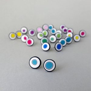 Handmade stud earrings with organic circles of turquoise on a white background with a black border.