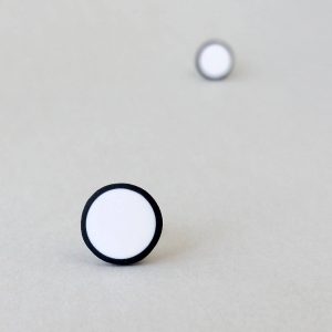 Handmade stud earrings in pure white with a black border.