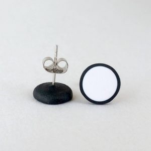 Handmade stud earrings in pure white with a black border.