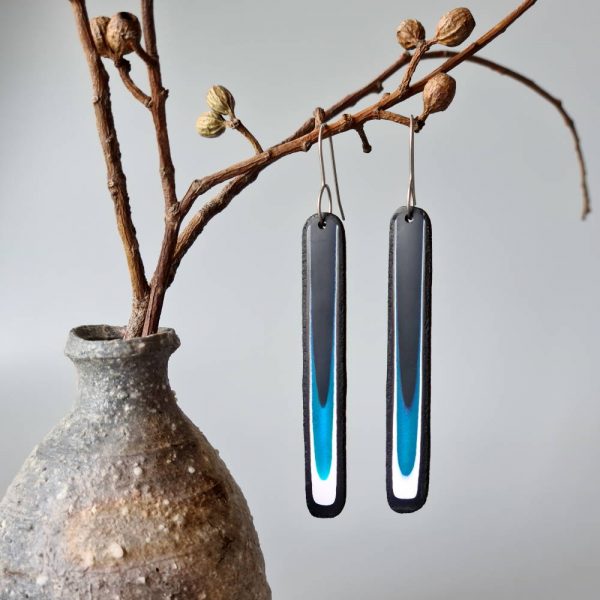 Handmade long dangle earrings with a clean, modern pattern in black, teal blue and white. Hand crafted titanium earwires.