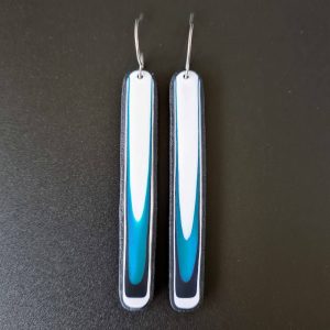 Handmade long dangle earrings with a clean, modern pattern in black, teal blue and white. Hand crafted titanium earwires.