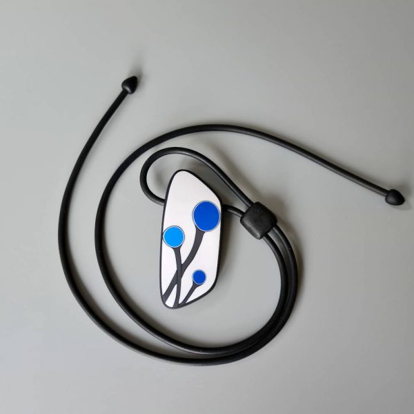 Handmade shield shaped necklace featuring an abstract flower bud motif in blue on a white background, with charcoal border. It is approximately 2.6 cm wide and 6.4cm long and hangs on a black adjustable cord.