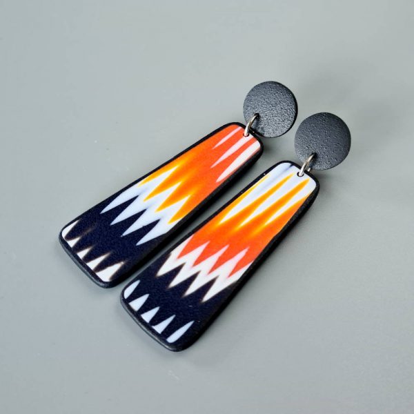 Handmade dangle earrings with zigzag pattern in black, white and orange.